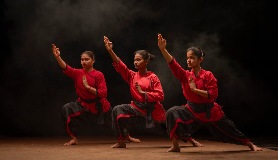 Kalaripayattu practitioners holding a stance in red practice attire
